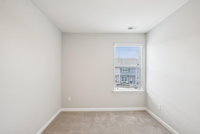 spare room with light carpet and baseboards