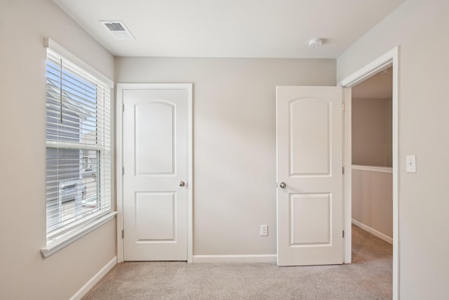 unfurnished bedroom with light colored carpet and baseboards