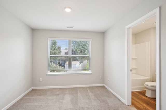 unfurnished room with baseboards and light carpet