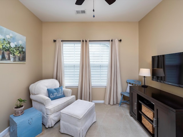 sitting room featuring ceiling fan, light carpet, and baseboards