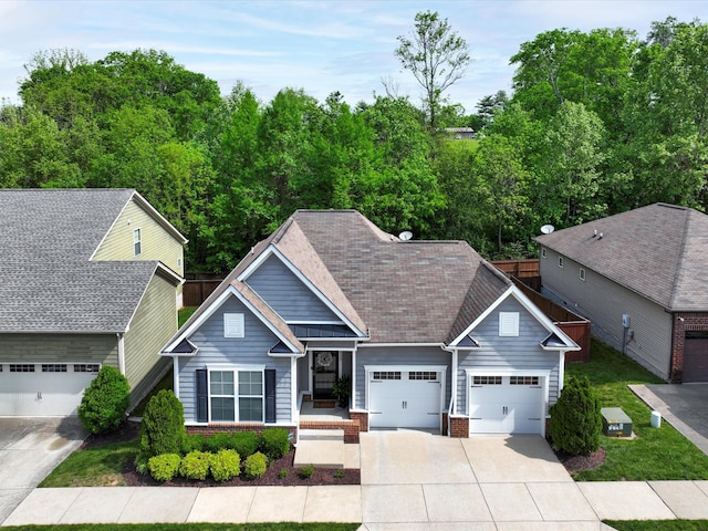 view of front of house featuring driveway, brick siding, an attached garage, and roof with shingles