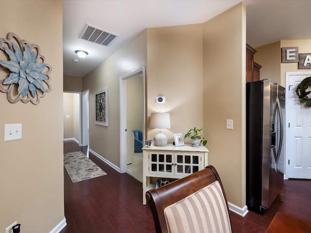 hall with dark wood-style flooring and baseboards
