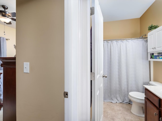 full bathroom with ceiling fan, vanity, toilet, and curtained shower