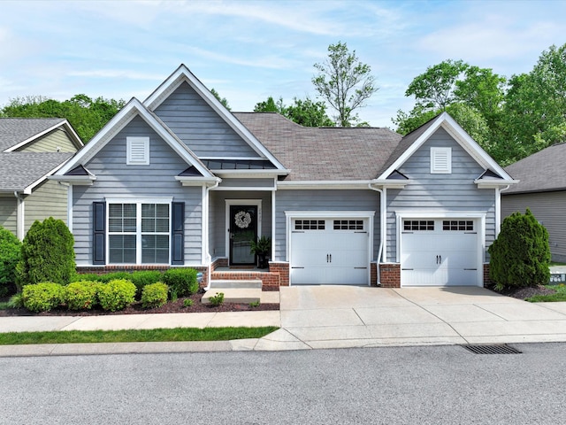 view of front facade with brick siding, concrete driveway, an attached garage, and a shingled roof