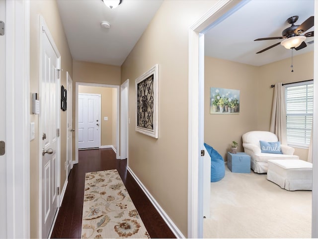 corridor featuring dark wood-type flooring and baseboards