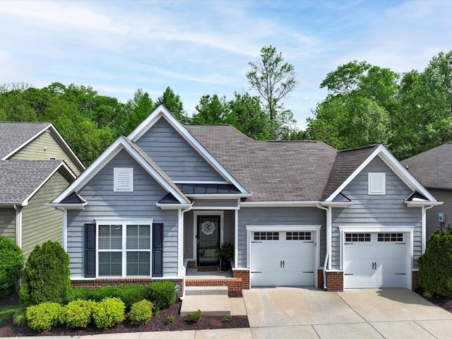 view of front of house featuring an attached garage, driveway, brick siding, and a shingled roof