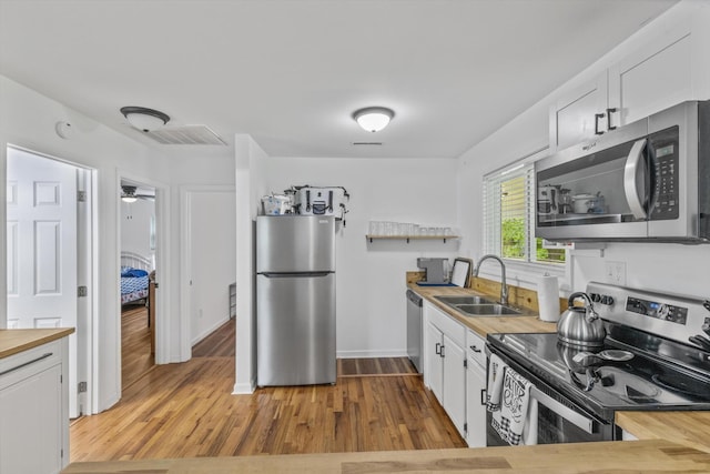 237 Windsor Ct, Spring City, TN 37381 - kitchen featuring appliances with stainless steel finishes, a sink, butcher block countertops, wood finished floors, and white cabinetry