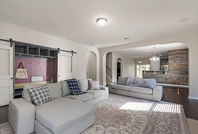 2303 Dewey Dr, Spring Hill, TN 37174 - living room featuring a barn door, arched walkways, wood finished floors, stairway, and a chandelier