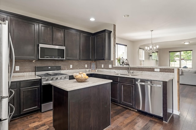 2303 Dewey Dr, Spring Hill, TN 37174 - kitchen featuring appliances with stainless steel finishes, a sink, a peninsula, open floor plan, and tasteful backsplash