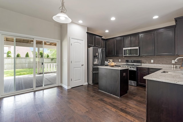 2303 Dewey Dr, Spring Hill, TN 37174 - kitchen featuring stainless steel appliances, a sink, a kitchen island, tasteful backsplash, and dark wood-style flooring