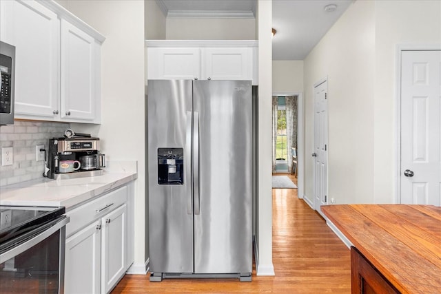 2025 Lewisburg Pike, Franklin, TN 37064 - kitchen with appliances with stainless steel finishes, backsplash, light wood-type flooring, white cabinetry, and ornamental molding