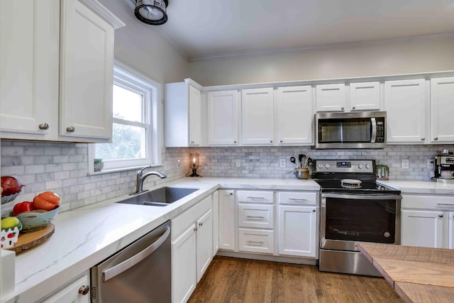 2025 Lewisburg Pike, Franklin, TN 37064 - kitchen with appliances with stainless steel finishes, a sink, ornamental molding, white cabinets, and decorative backsplash