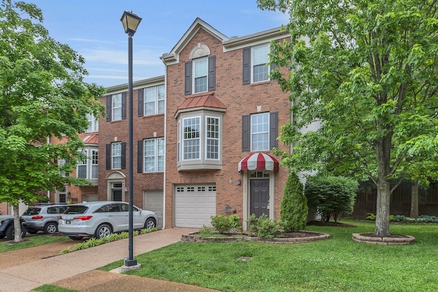 multi unit property with driveway, an attached garage, brick siding, and a front yard