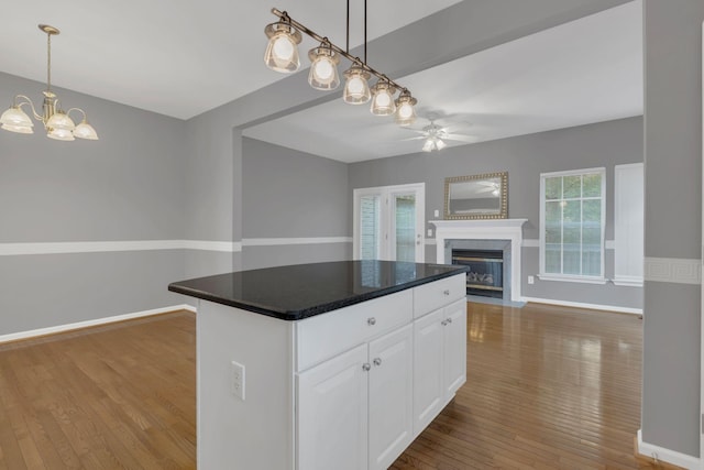 kitchen with a ceiling fan, wood-type flooring, open floor plan, and plenty of natural light