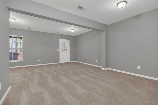 unfurnished room with light carpet and baseboards