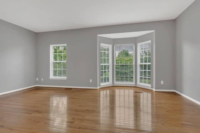 unfurnished room with wood finished floors and baseboards