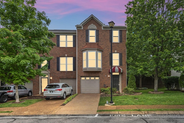 multi unit property featuring driveway, an attached garage, brick siding, and a lawn