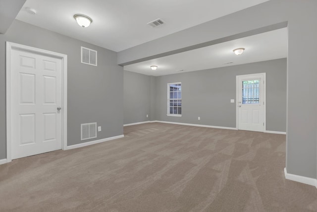 empty room featuring light carpet and baseboards