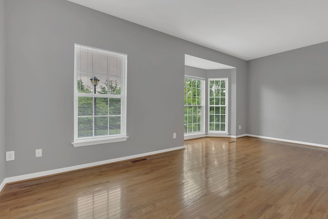 spare room with wood finished floors and baseboards