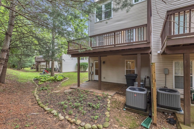 back of property featuring cooling unit, a patio area, a deck, and a yard