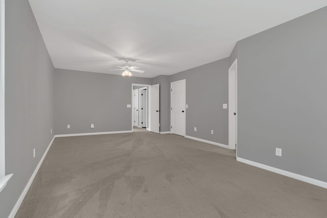 spare room with ceiling fan, baseboards, and carpet flooring