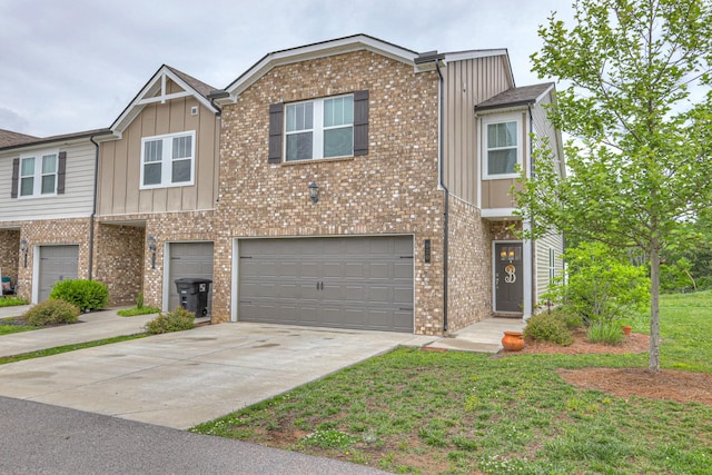 view of property with board and batten siding, an attached garage, driveway, brick siding, and a front yard