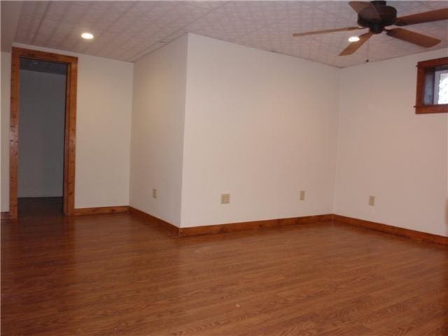 empty room with wood finished floors, baseboards, a ceiling fan, and recessed lighting
