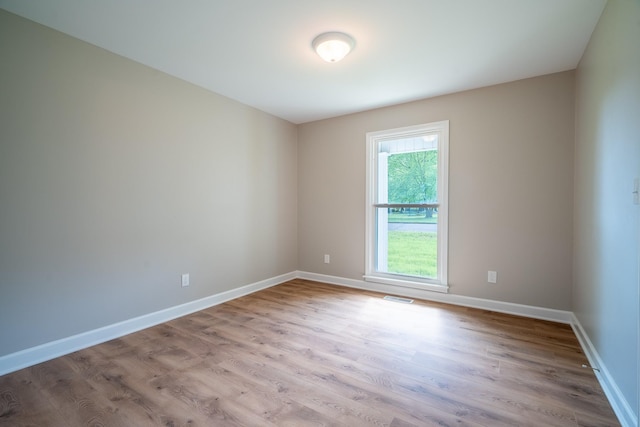 spare room with wood finished floors and baseboards
