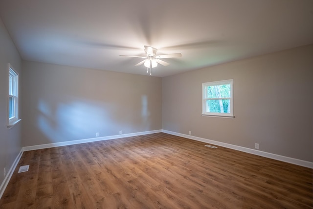 unfurnished room with wood finished floors, ceiling fan, and baseboards