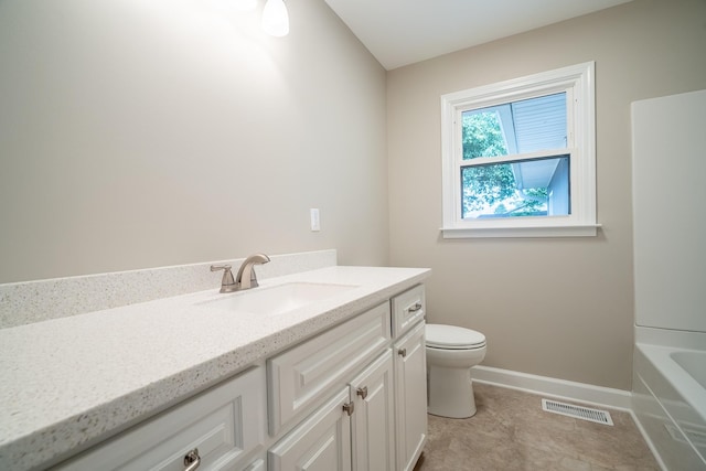 bathroom featuring vanity, toilet, baseboards, and a bath