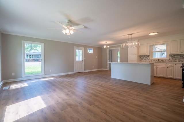 kitchen with ornamental molding, a chandelier, a center island, healthy amount of natural light, and light countertops