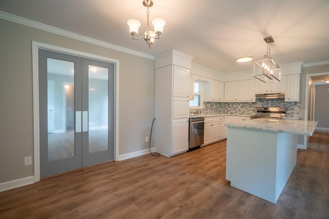 kitchen with stainless steel appliances, under cabinet range hood, french doors, a chandelier, and white cabinetry