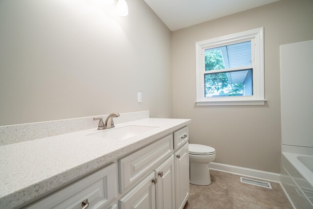 bathroom featuring vanity, toilet, baseboards, and a bath