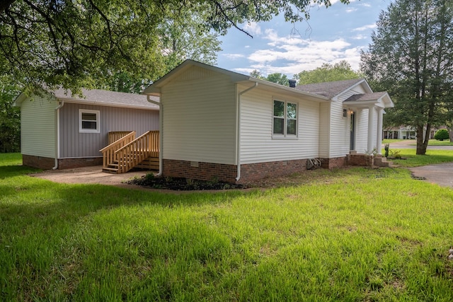rear view of property with a yard, roof with shingles, and crawl space