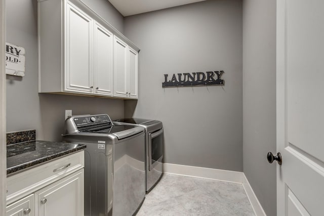 clothes washing area with washing machine and dryer, cabinet space, baseboards, and tile patterned floors