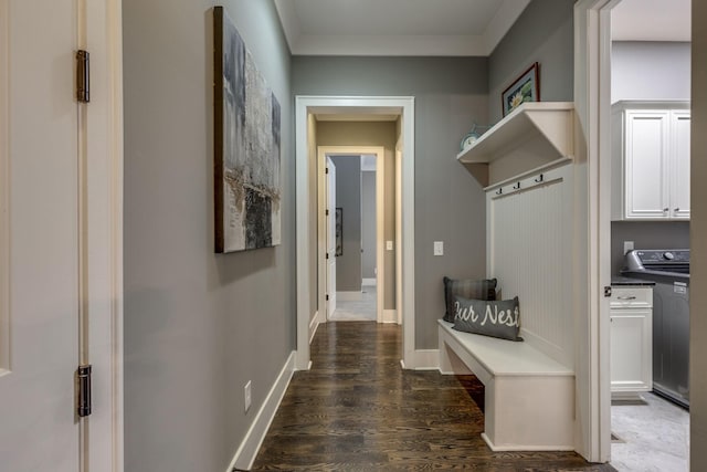 mudroom with washer / dryer, dark wood-style flooring, ornamental molding, and baseboards