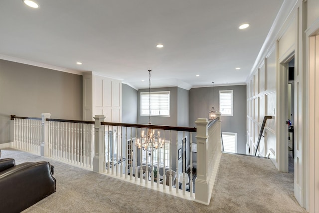 corridor with carpet floors, an upstairs landing, recessed lighting, ornamental molding, and a chandelier