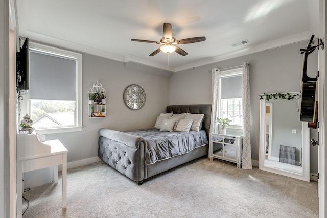 carpeted bedroom featuring multiple windows, baseboards, crown molding, and ceiling fan