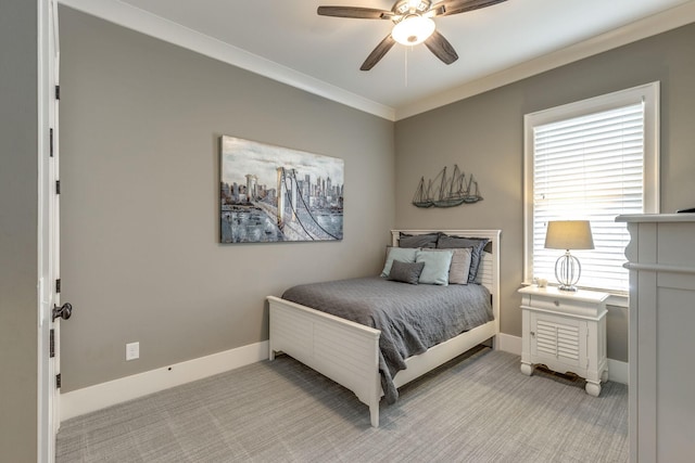 bedroom featuring light colored carpet, baseboards, a ceiling fan, and ornamental molding