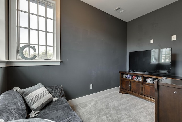 living area featuring carpet flooring, plenty of natural light, and baseboards