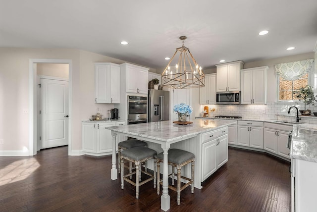 6752 Falls Ridge Ln, College Grove, TN 37046 - kitchen featuring stainless steel appliances, a sink, a chandelier, white cabinets, and a center island