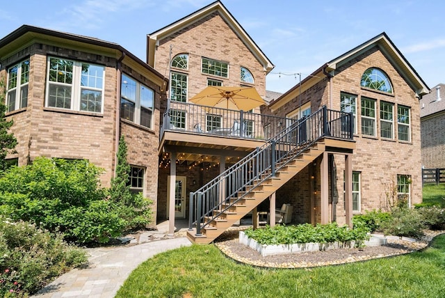 6752 Falls Ridge Ln, College Grove, TN 37046 - back of property featuring brick siding, stairway, a wooden deck, and a lawn