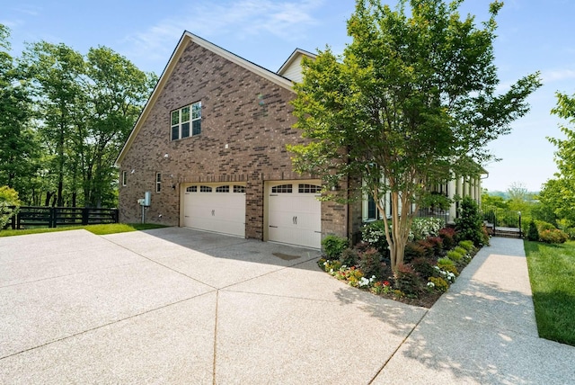 6752 Falls Ridge Ln, College Grove, TN 37046 - view of side of property with driveway, brick siding, an attached garage, and fence