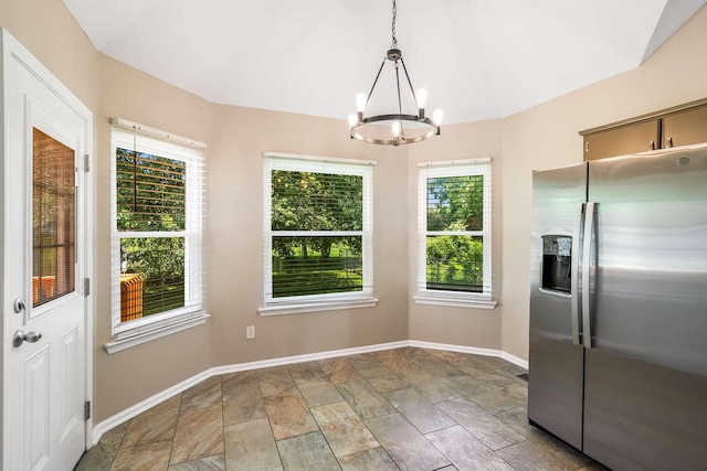 unfurnished dining area with a chandelier, baseboards, and light stone finish flooring