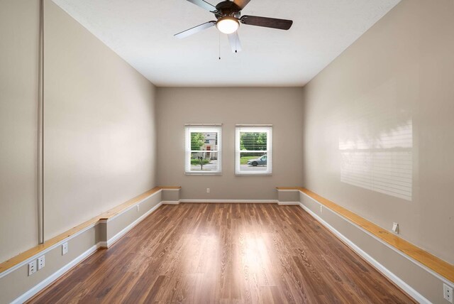 unfurnished room featuring wood finished floors, a ceiling fan, and baseboards