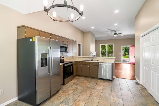 kitchen featuring appliances with stainless steel finishes, a sink, a chandelier, a peninsula, and ceiling fan