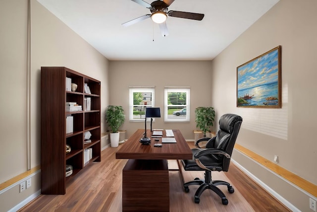 home office featuring a ceiling fan, wood finished floors, and baseboards