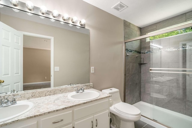 full bath with toilet, a stall shower, and double vanity
