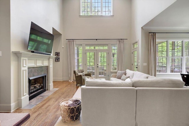 2507 Eagle Creek Way, Signal Mountain, TN 37377 - living area featuring a towering ceiling, light wood finished floors, a tile fireplace, healthy amount of natural light, and baseboards