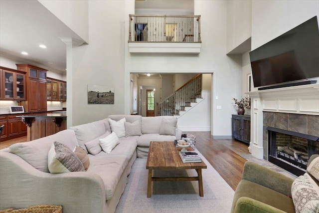 2507 Eagle Creek Way, Signal Mountain, TN 37377 - living room featuring a high ceiling, light wood finished floors, stairway, a tile fireplace, and baseboards